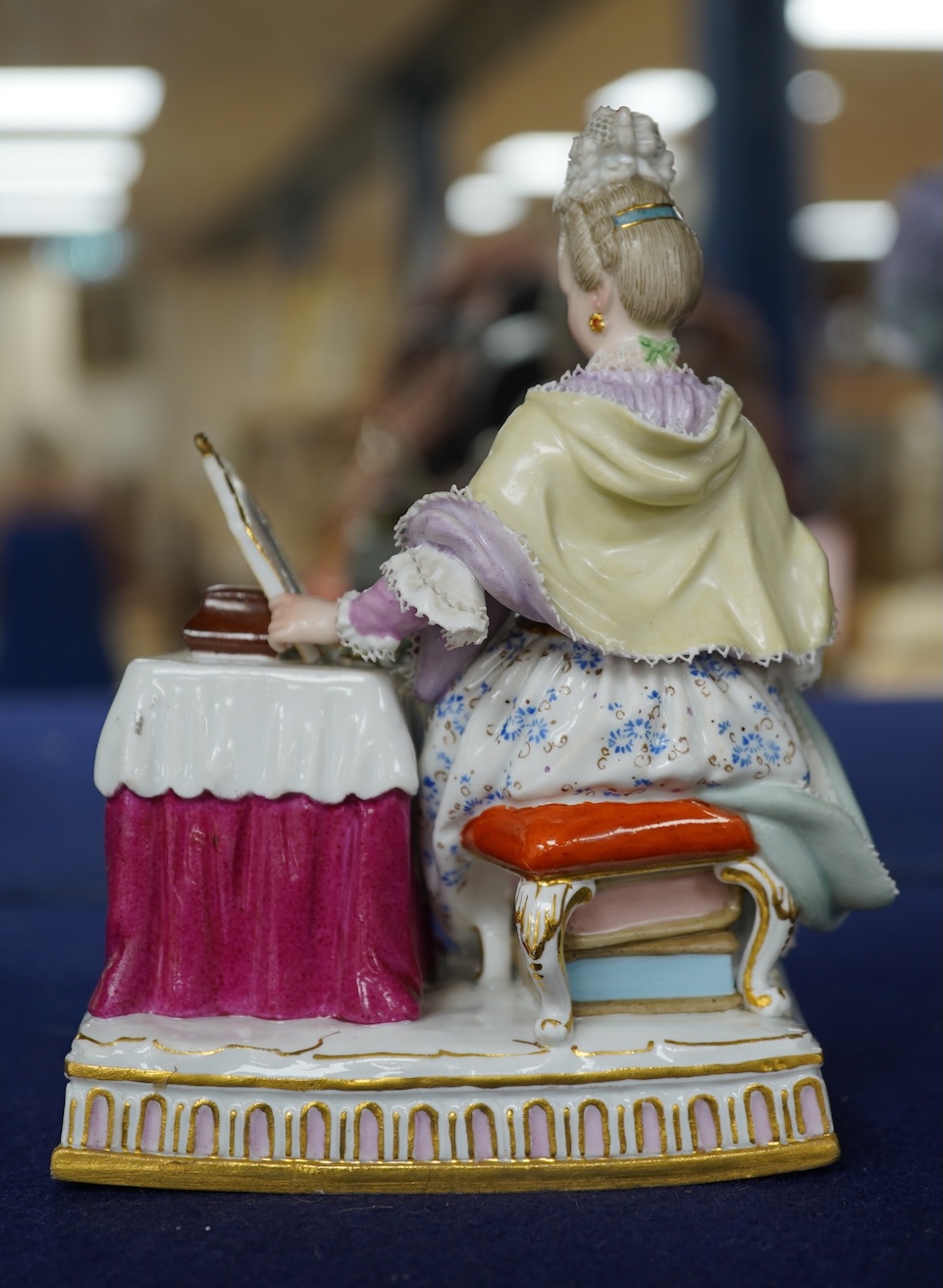 A late 19th century Meissen figure of Sight, from the Senses, a seated lady at her dressing table, crossed swords mark and incised E3 mark to base, 14cm high